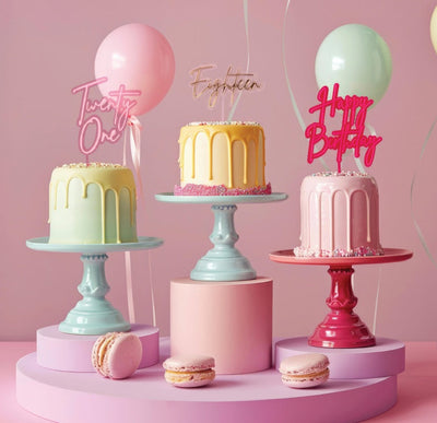 Selection of acrylic cake toppers diplayed on cakes