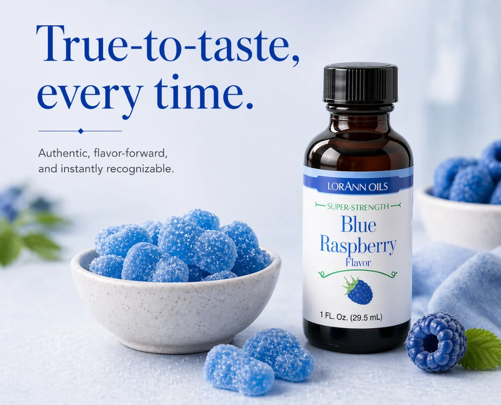 A bottle of LorAnn Oils Blue Raspberry flavor stands next to a small bowl of blue raspberry candies on a light blue surface. Large text at the top reads, 'True-to-taste, every time.