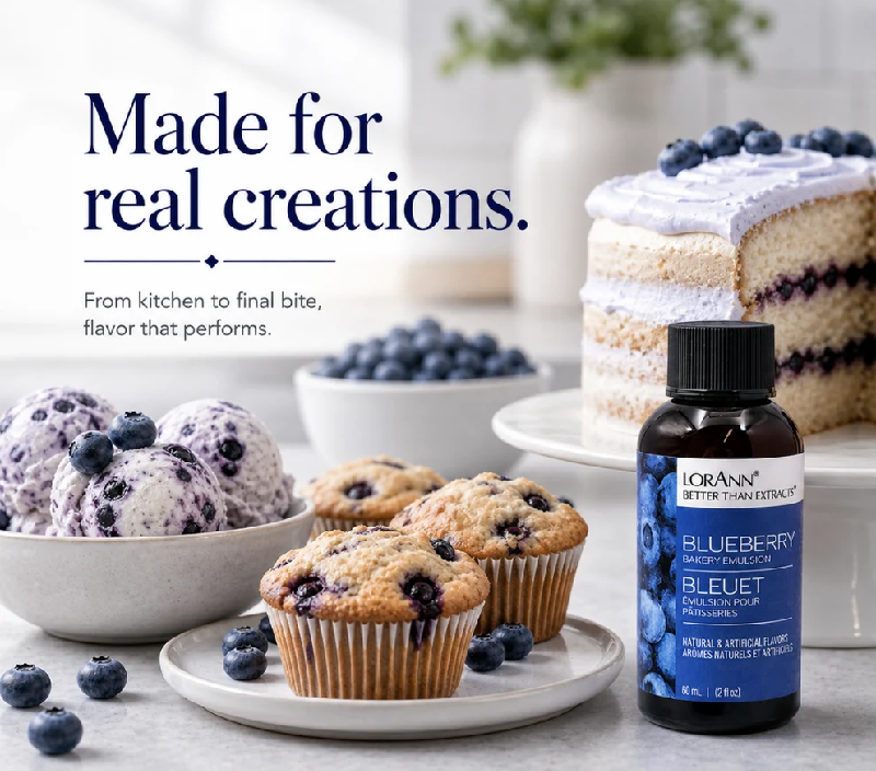 A bottle of LorAnn Blueberry Flavoring shown in a styled kitchen scene with blueberries, blueberry muffins, blueberry ice cream, and a blueberry cake. Text on the image reads 'Made for real creations.
