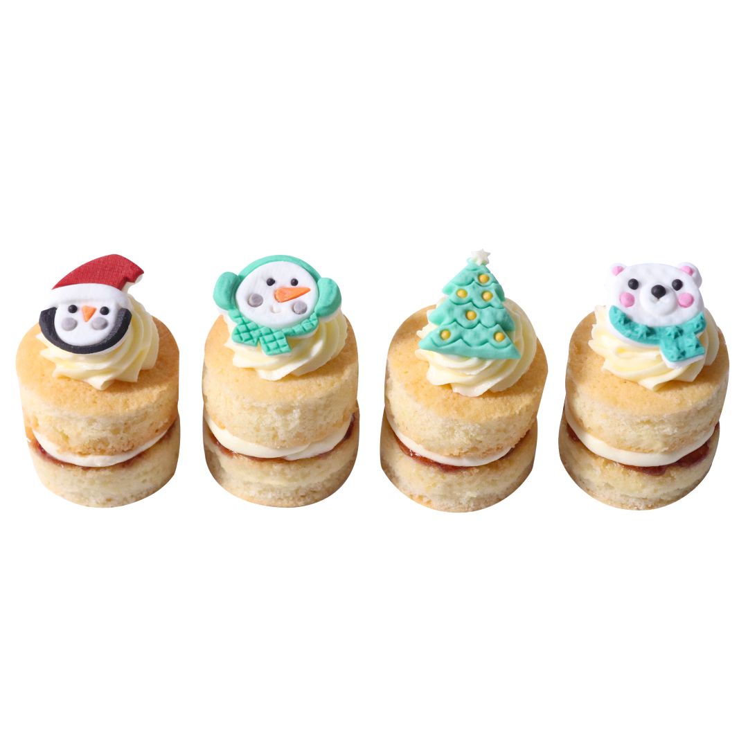 Four small cake stacks with festive decorations on a white background