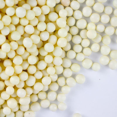 Close-up of white chocolate pearls on a white background