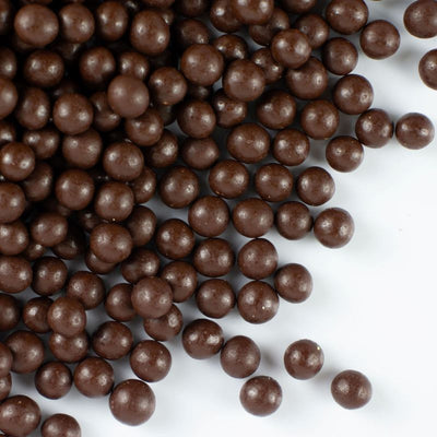 Close-up of chocolate pearls on a white background