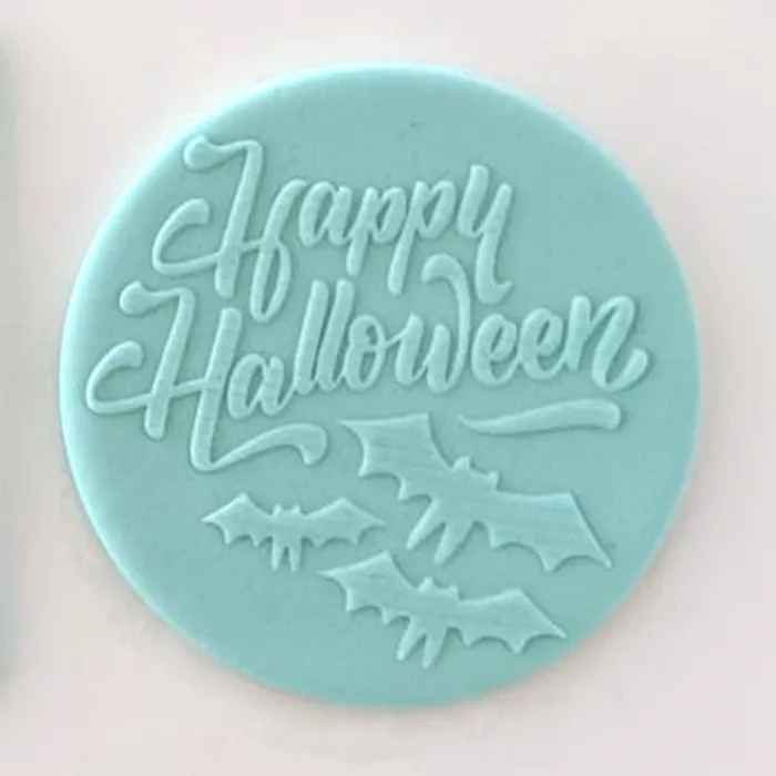 A blue fondant plaque embossed with Happy Halloween and a flock of bats