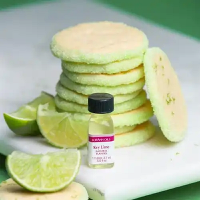 Natural Key Lime lorann flavouring with a stack of cookies and cut limes
