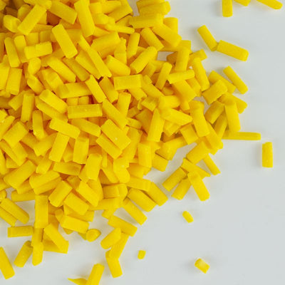 Yellow chocolate chips scattered on a white background