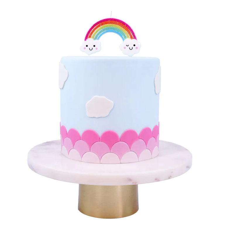 Children's birthday cake with rainbow and cloud decorations on a white background