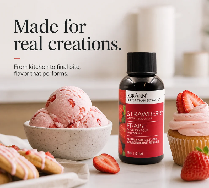 Lorann Better Than Extract Strawberry Emulsion bottle displayed next to a bowl of fresh strawberry ice cream and a cupcake