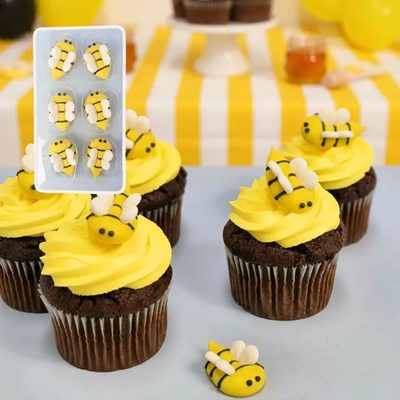 Cupcakes decorated with yellow frosting and bee-shaped icing decorations.