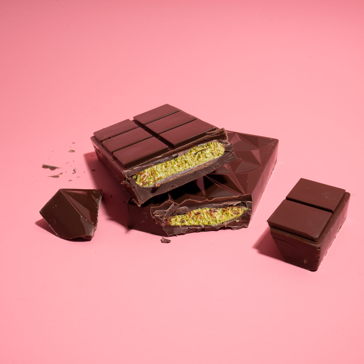 Chocolate bar with pistachio filling on a pink background