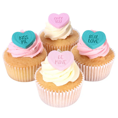 Cupcakes with conversation heart toppers on a white background