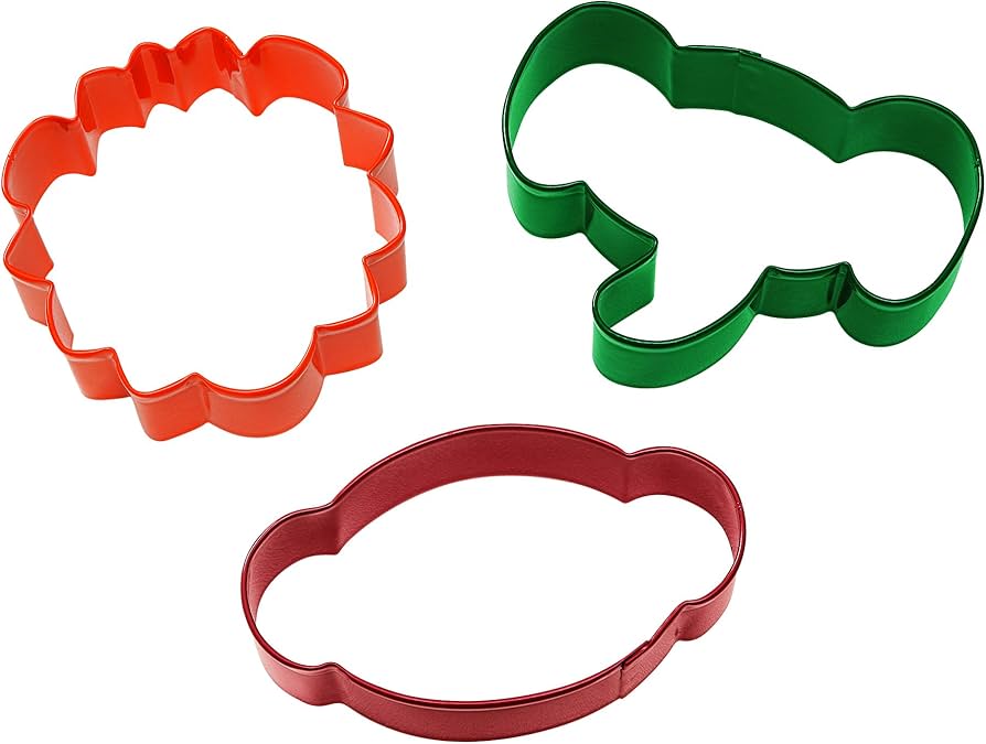 Three jungle animal-shaped cookie cutters in brown, green, and orange on a white background