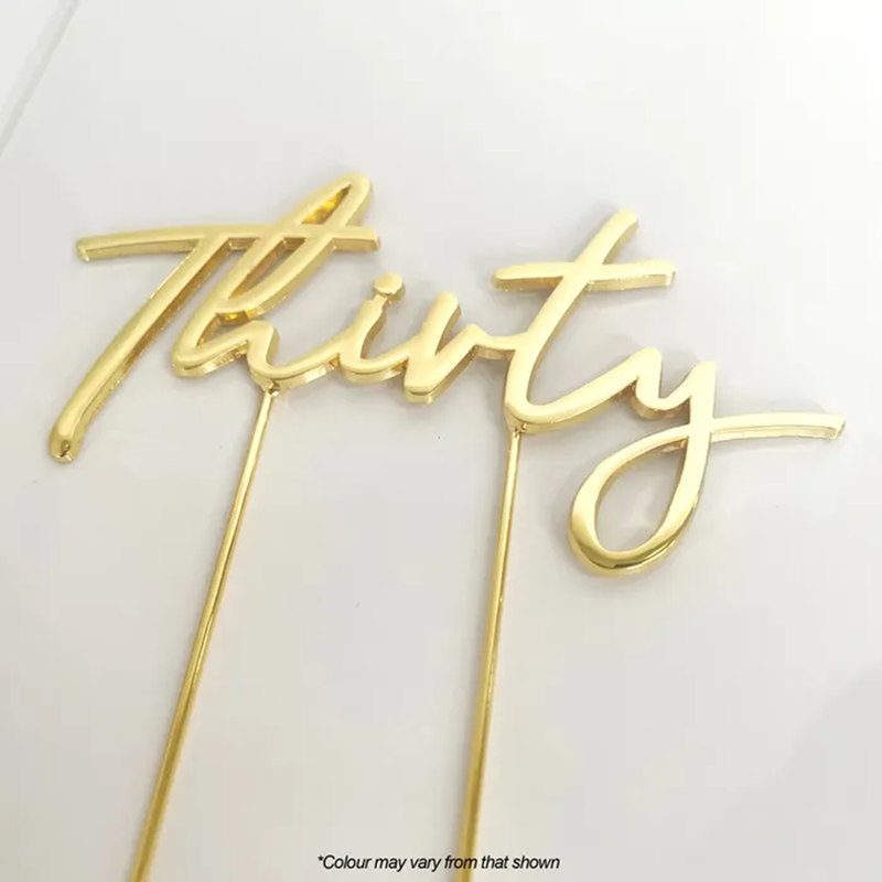 Gold 'Thirty' cake topper on a white background