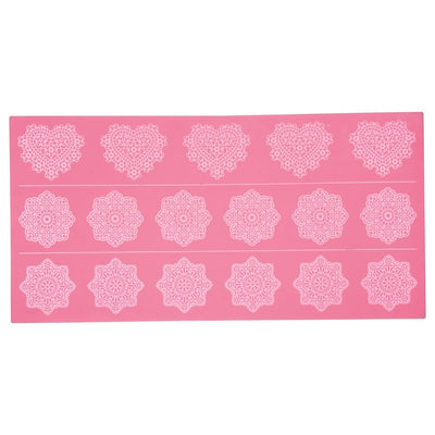 A pink silicone lace mat with various intricate lace patterns, used for cake decorating.