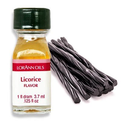 A small bottle labeled Lorann Oils Licorice Flavor with a quantity of 1 dram, next to a cluster of black licorice candy.
