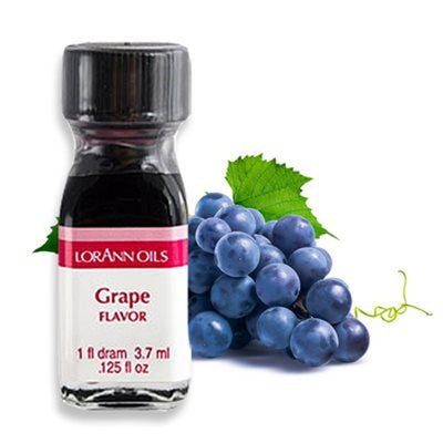 A bottle of Lorann Oils Grape flavoring next to a cluster of grapes.