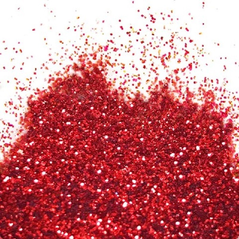 A close-up image of scarlet red flitter glitter spread on a white background.