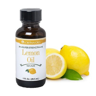 A bottle of LORANN OILS Lemon Oil next to a lemon and a lemon slice on a white background.