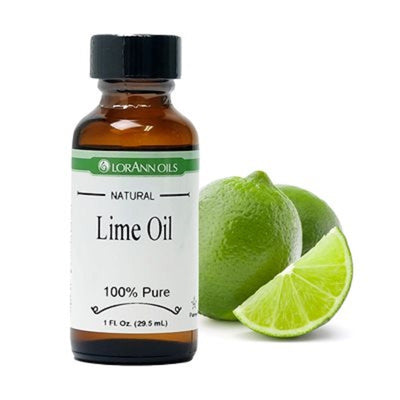 A bottle of LORANN OILS natural Lime Oil next to a slice of lime and a whole lime.