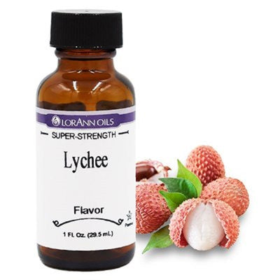 A bottle of Lorann Oils super-strength lychee flavoring, next to a cluster of lychee fruits with leaves.