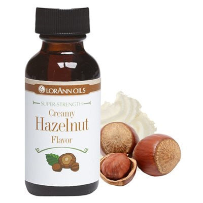 A bottle of Lorann Oils Creamy Hazelnut flavoring with hazelnuts and whipped cream depicted next to it.