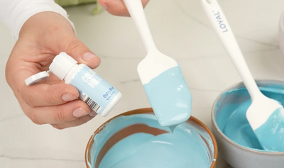 Bowls of blue coloured chocolate. With bottle of colourmill colouring