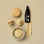 Bottle of 'Sprink' with a dropper, surrounded by macarons and cream on a beige background