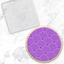 A round cookie with a purple and white geometric maze-like pattern, shown next to a clear plastic debosser with the same white pattern, on a white marble background.