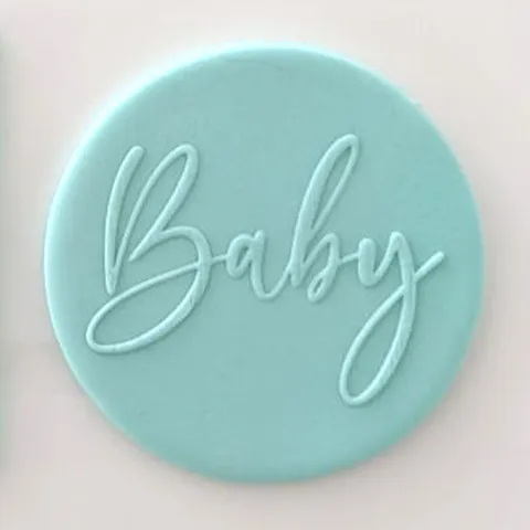 Round turquoise fondant with 'Baby' text embossed onit. On  a light pink background