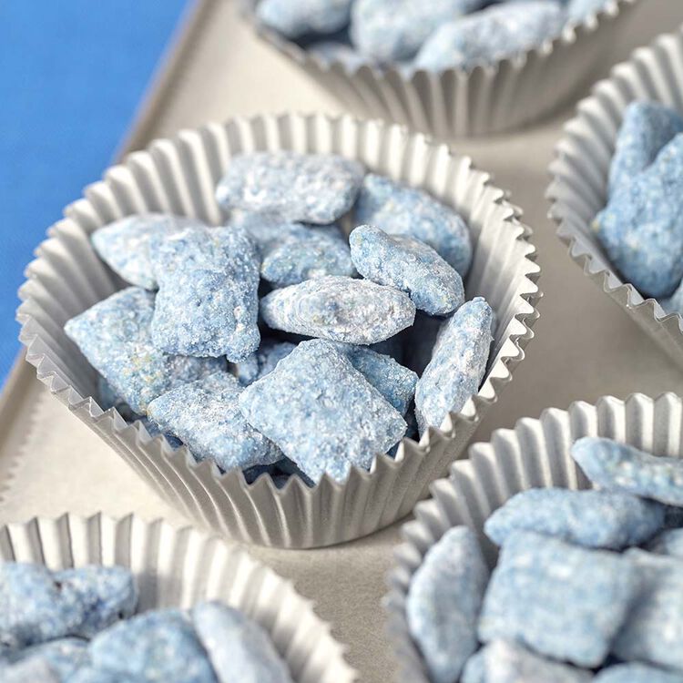 Puppy chow treats made by dipping in blue candy melts and powdered sugar