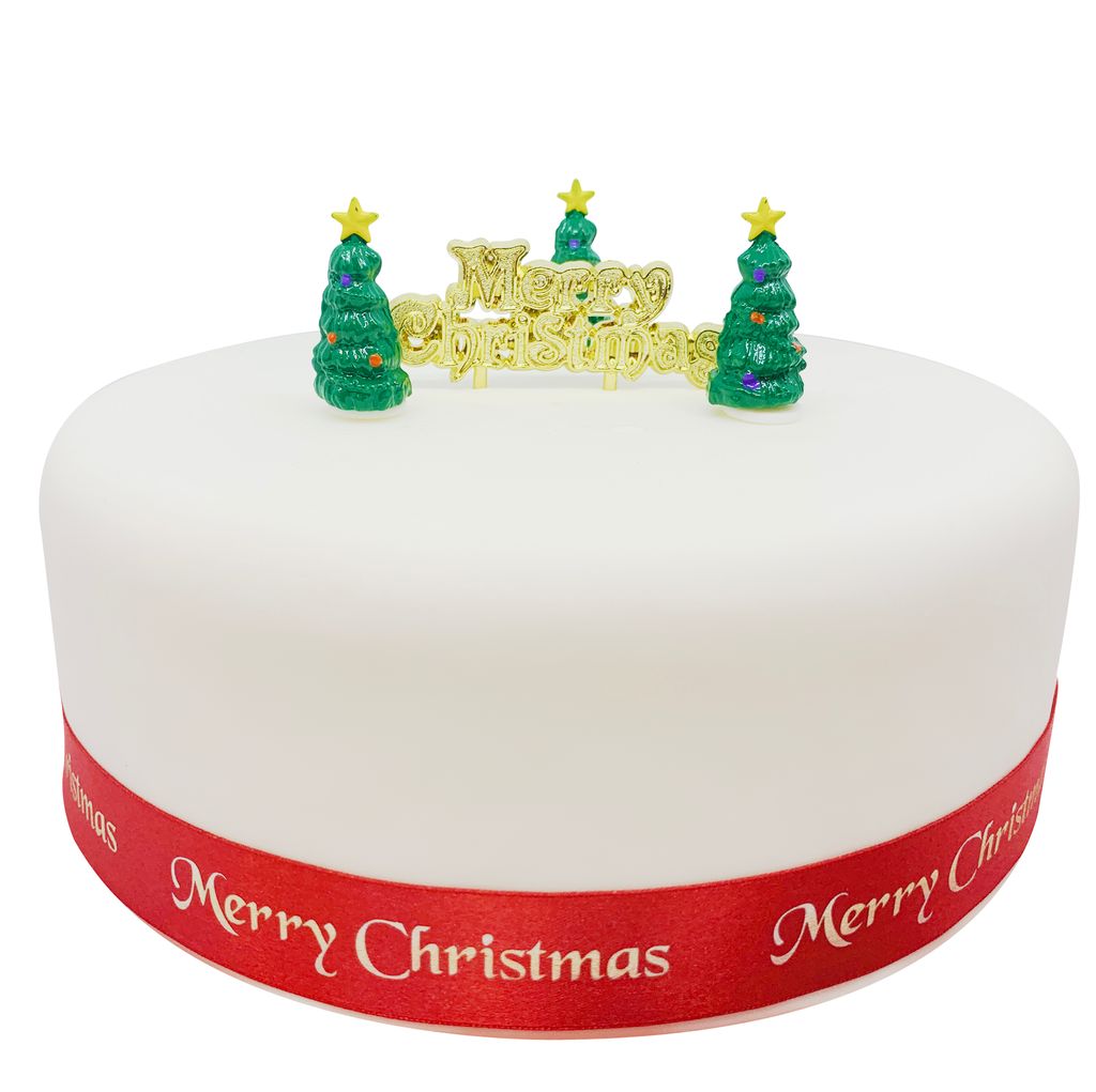 Christmas cake with a gold plaque and three christmas tree toppers
