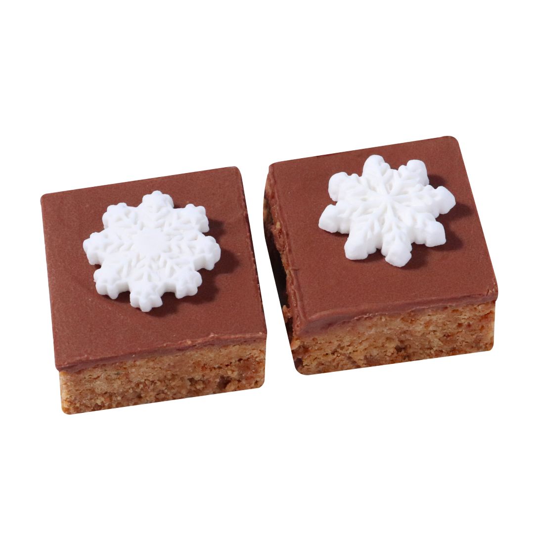 Two square chocolate treats with white snowflake decorations on a white background