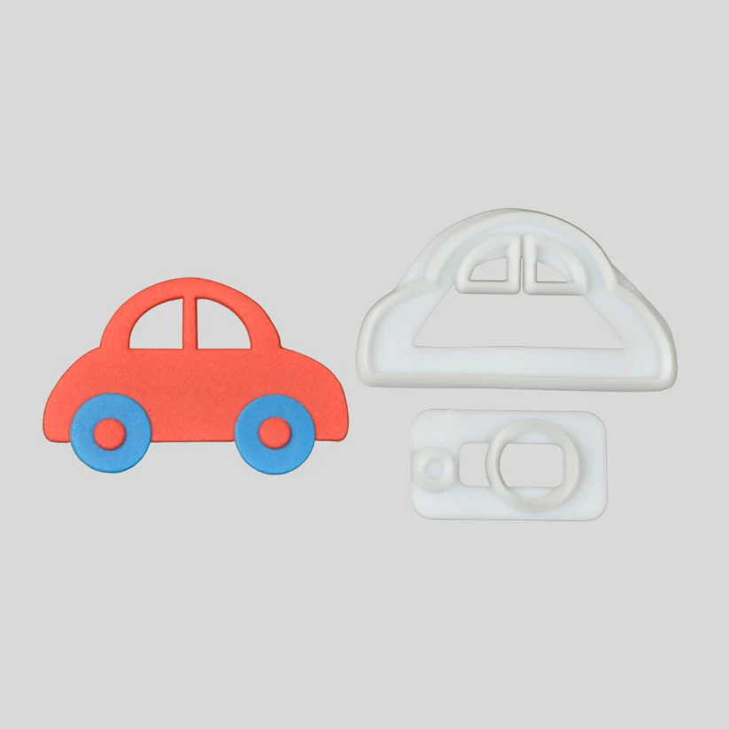 A car-shapedfondant cutter set shown on a light gray background, featuring a red car with blue wheels and two white plastic cutter templates.