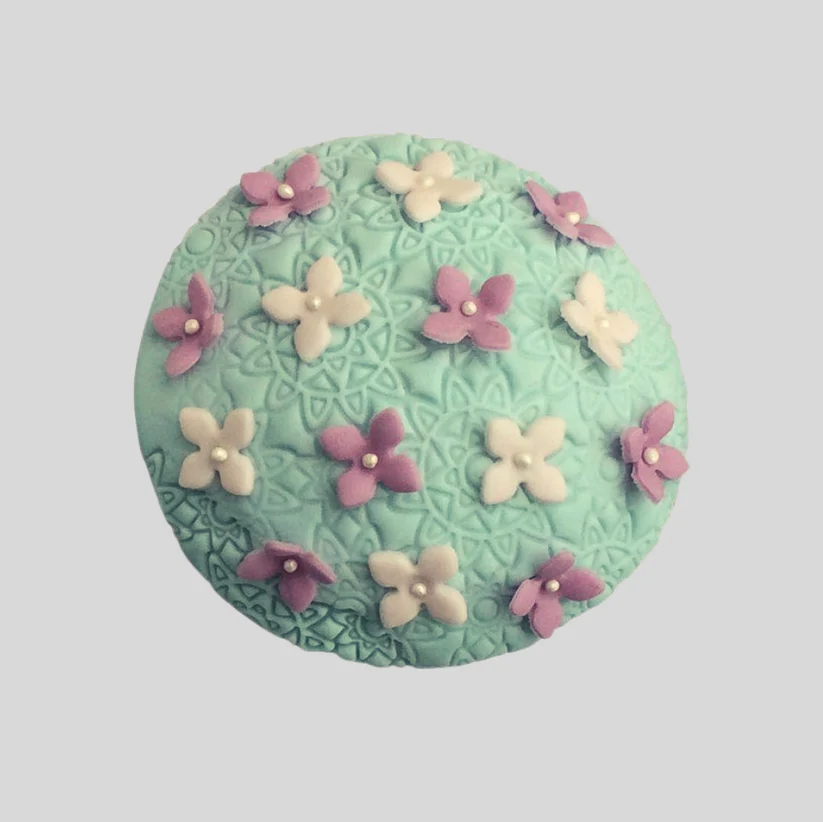 Mini daphne flowers on top of a mint green cupcake