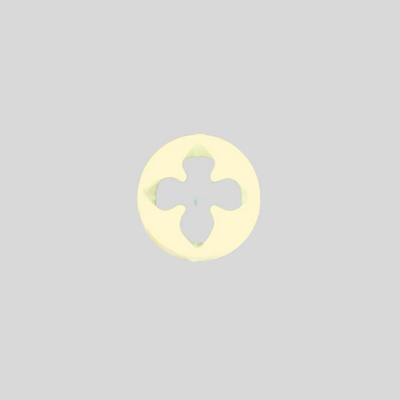 A pale yellow gumpaste flower cutter with a four-pointed star cutout in the center, shown on a solid light gray background.