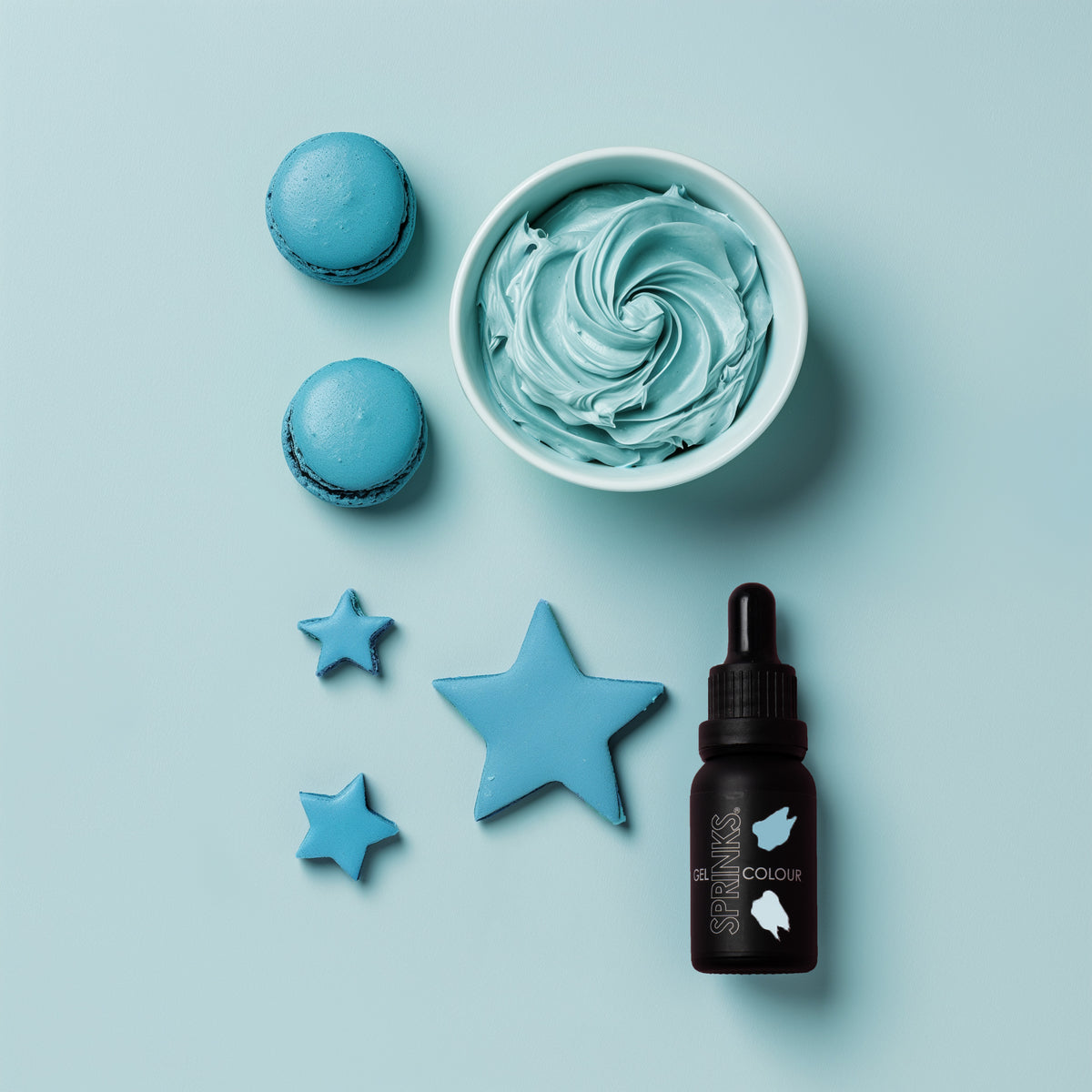 Blue-themed icing examples including a bowl of blue buttercream, macarons, star-shaped fondant cut outs, and a bottle on a light blue background.