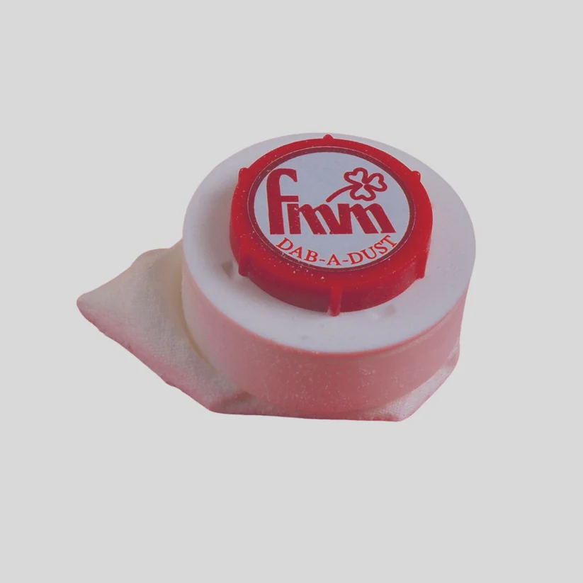 A small cylindrical white product with a red top cap featuring the brand name 'fmm' and the text 'DAB-A-DUST', photographed on a plain light gray background.