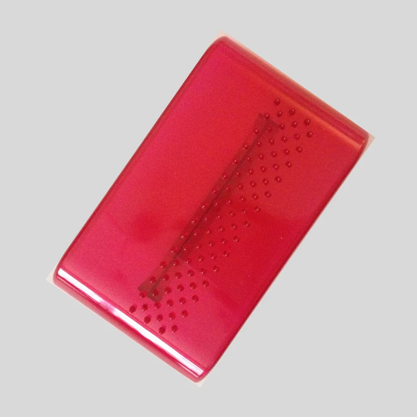 Red rectangular object with a textured surface on a gray background for imprinting fondant. Made by fmm