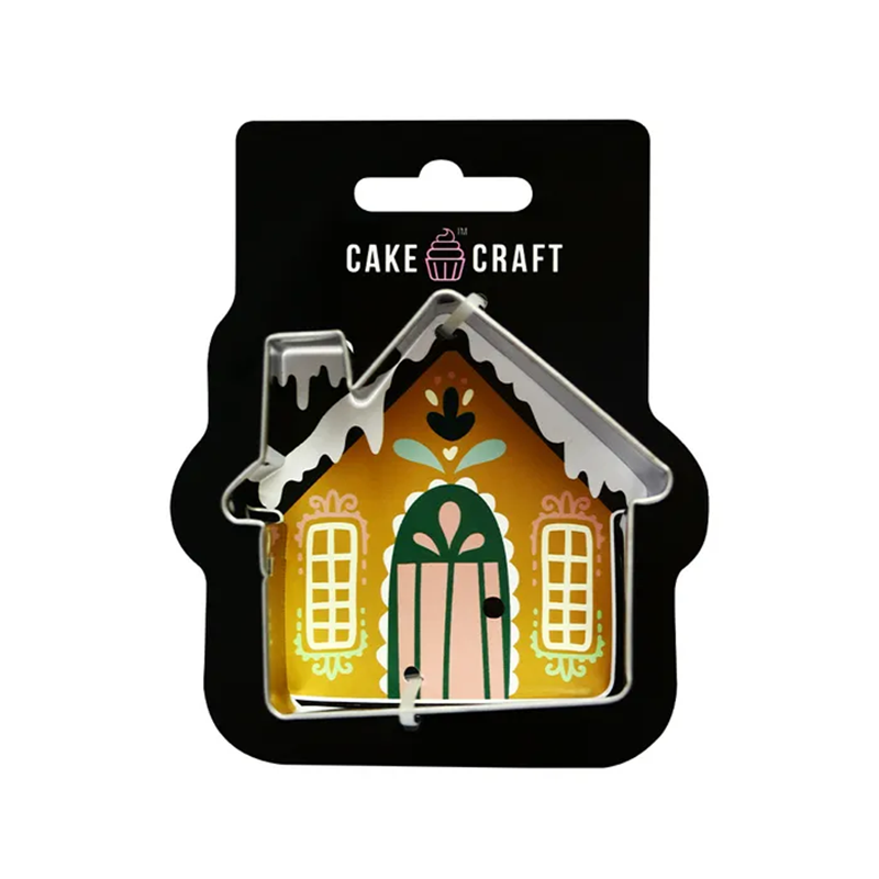 Gingerbread house-shaped cookie cutter with decorative design on a black Cake Craft packaging