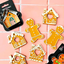 Gingerbread house and gingerbread man cookies on a pink tiled background