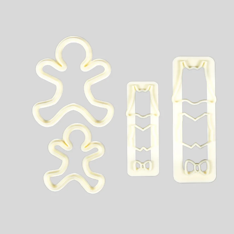 Three cream-colored plastic cutters, including gingerbread men and rectangular clothing pattern cutters, arranged on a solid light gray background.