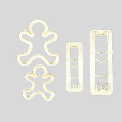 Three cream-colored plastic cutters, including gingerbread men and rectangular clothing pattern cutters, arranged on a solid light gray background.