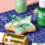Star-shaped cookie with green and gold marbled icing on a blue cutting mat with Colour Mill products.