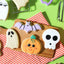 Halloween-themed cookies on a wooden board with a striped cloth underneath.
