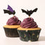 Two cupcakes with purple frosting and bat-shaped toppers on a white background
