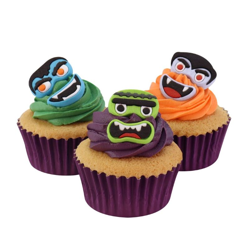 Three cupcakes with monster-themed frosting and decorations