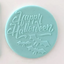 A blue fondant plaque embossed with Happy Halloween and a flock of bats