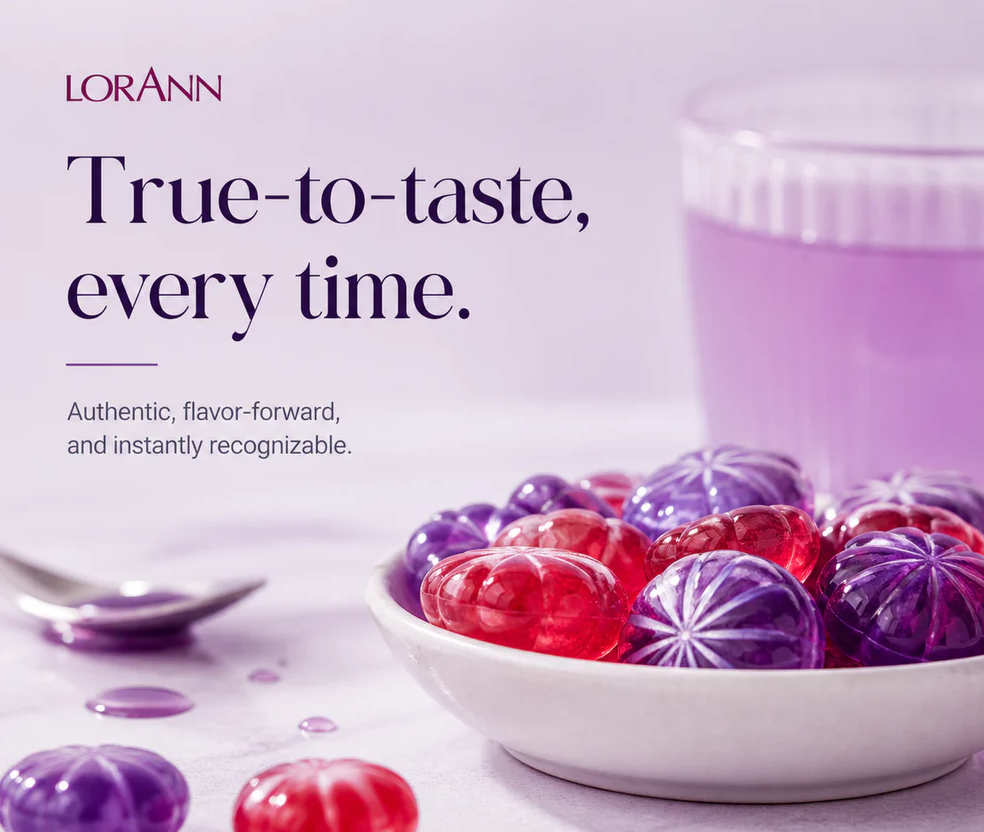A promotional product shot for LORANN featuring a white bowl filled with translucent candies in red and purple, with a glass of matching purple liquid and a spoon on a light surface. Large text reads 'True-to-taste, every time.