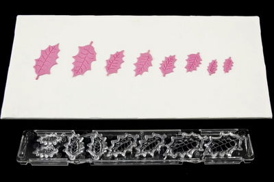 Holly leaf plastic clikstix cutter. Alongside pink fondant icing examples of each leaf size