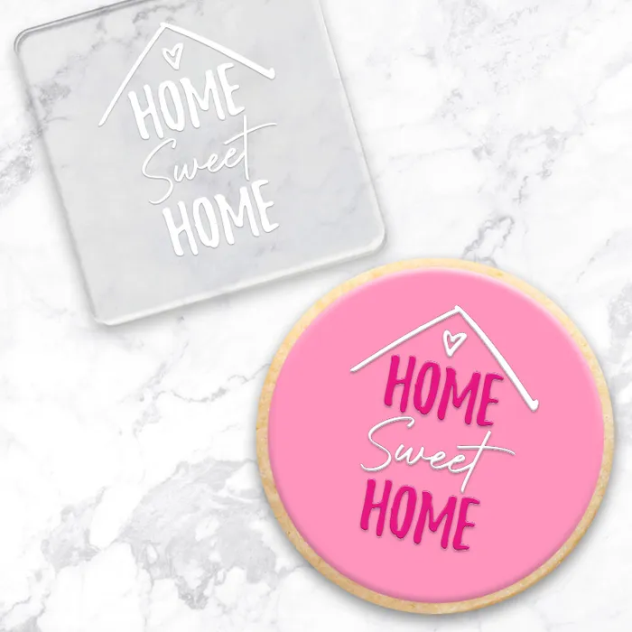 Clear acrylic debosser tool with Home Sweet Home. Alongside a pink cookie showcasing its end result