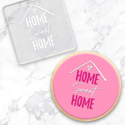 Clear acrylic debosser tool with Home Sweet Home. Alongside a pink cookie showcasing its end result